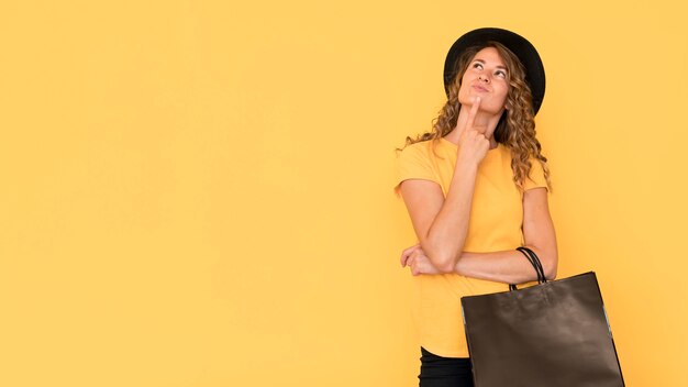 Woman holding black friday shopping bag copy space