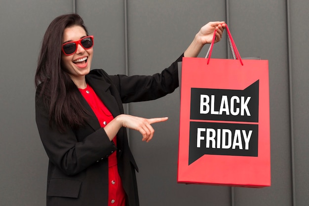 Foto gratuita donna che tiene una borsa della spesa del venerdì nero