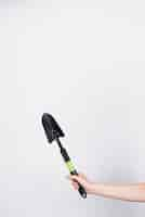 Free photo woman holding black shovel with copy space