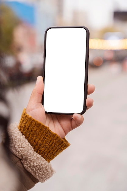 Foto gratuita donna che tiene uno smartphone in bianco