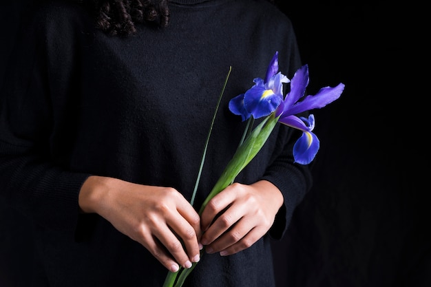 여자가 손에 파란 꽃을 들고