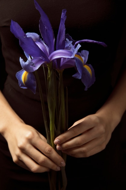 Woman holding blue flowers in hands 