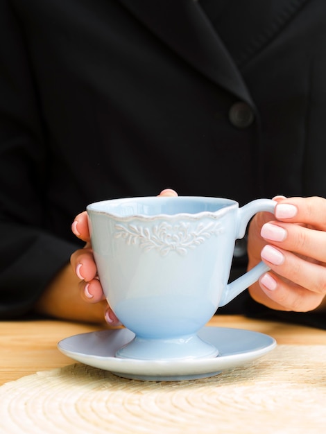 Free photo woman holding blue teacup