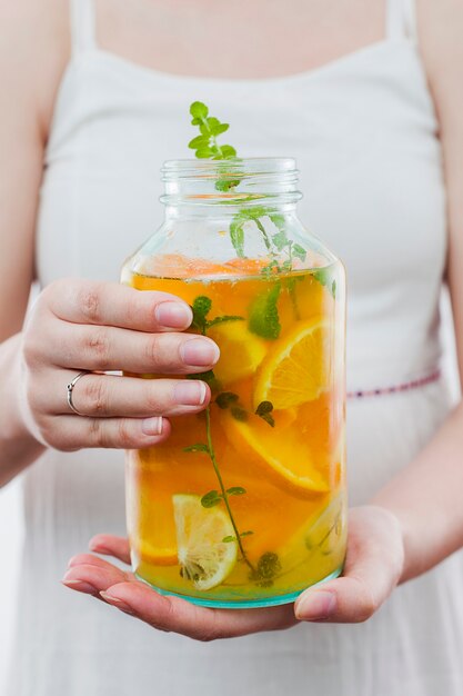 woman holding bottle of citrus drink