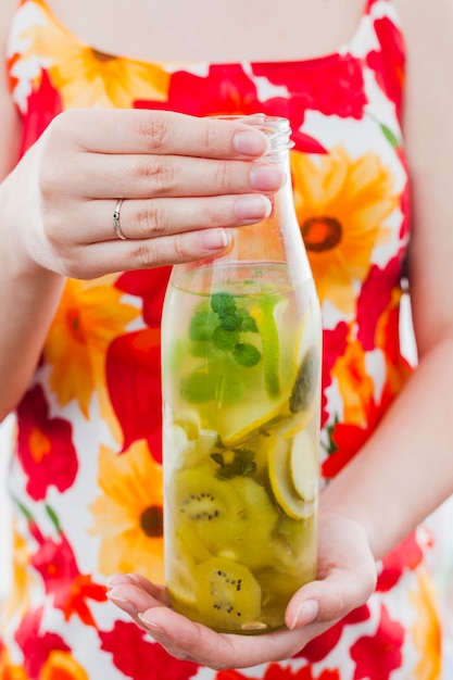 Woman holding bottle of fruit drink