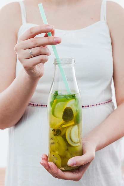 Woman holding bottle of green lemonade