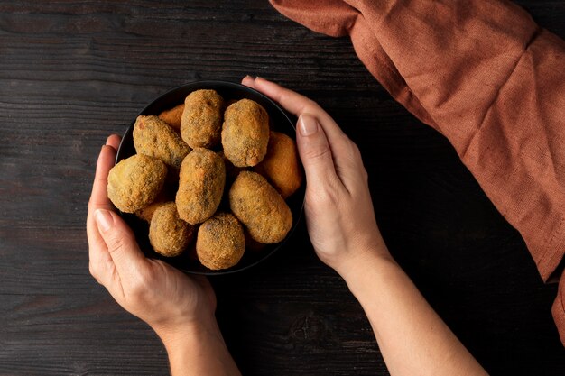 Woman holding a bowl with croquettes