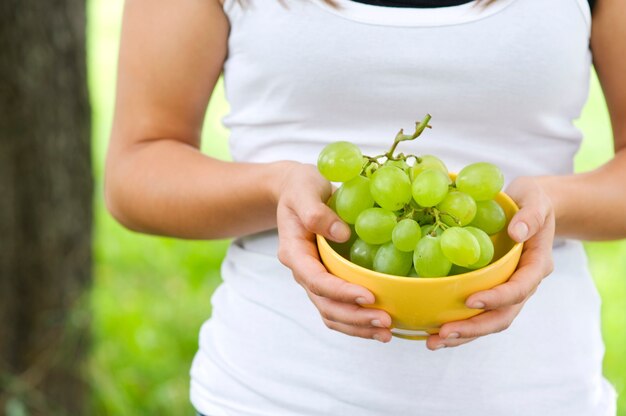 Woman holding bowl with grapesxa