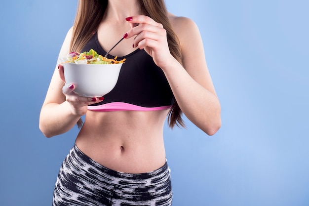 Free photo woman holding bowl with vegetable salad