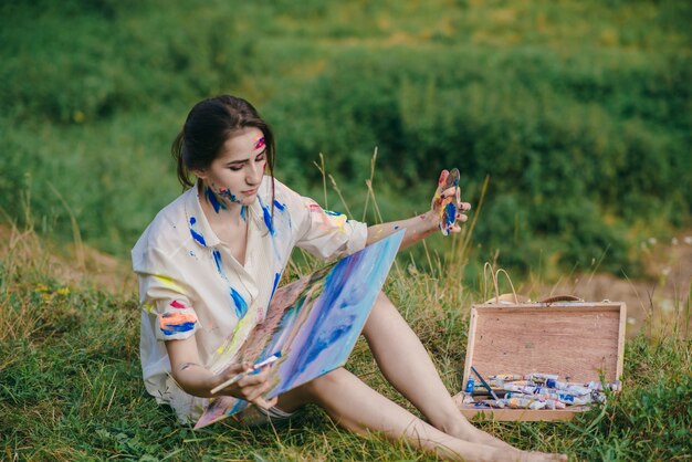 바닥에 앉아있는 동안 그녀의 다리와 상자를 들고 여자