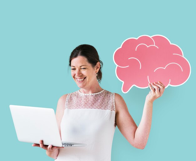 Woman holding a brain icon and using a laptop