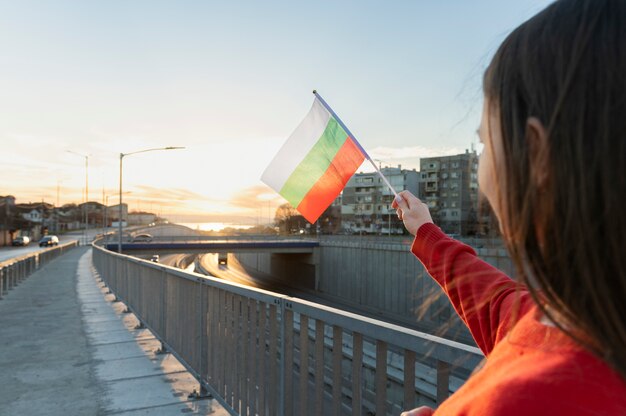 Женщина держит болгарский флаг на улице