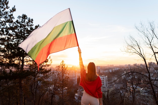 야외에서 불가리아 국기를 들고 있는 여자