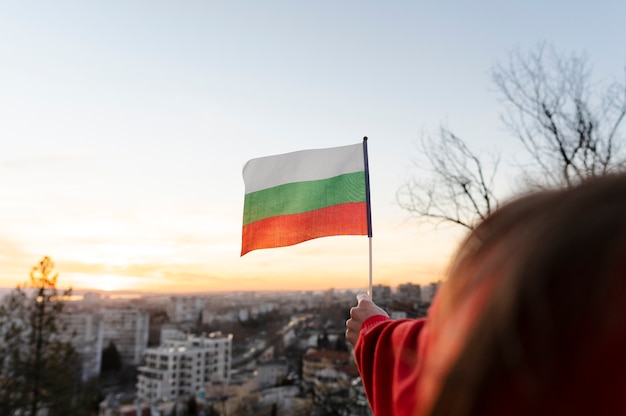 Женщина держит болгарский флаг на улице