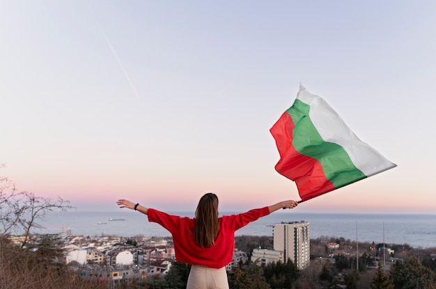 Woman holding bulgarian flag outdoors