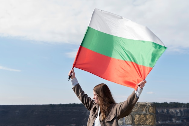 ブルガリアの国旗を屋外で保持している女性