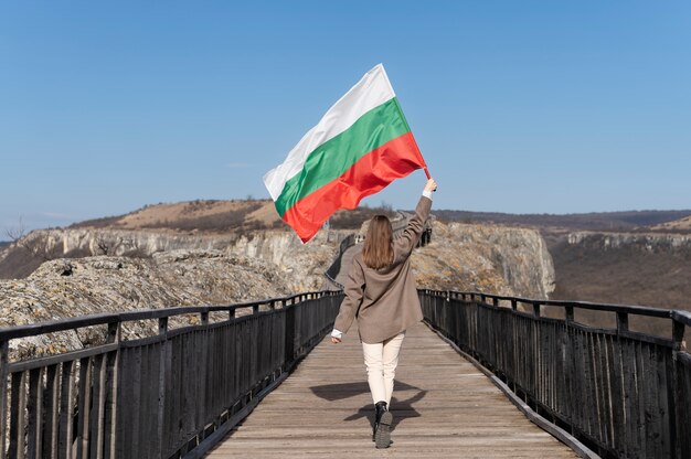 야외에서 불가리아 국기를 들고 있는 여자