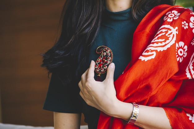 Free photo woman holding a buta shape jewelry pin