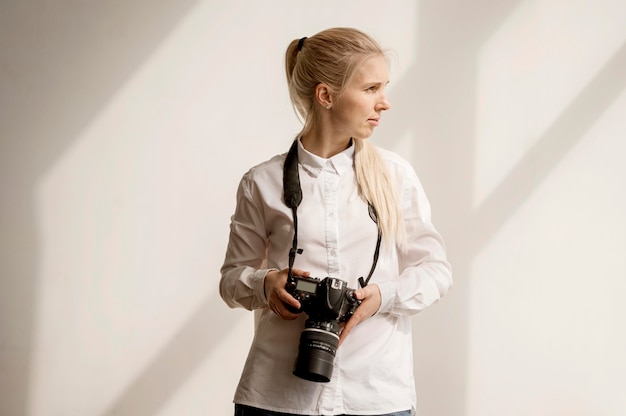 Woman holding a camera photo looking away