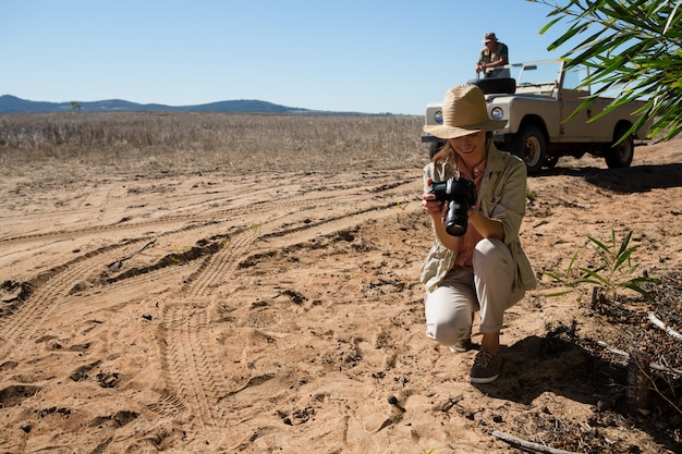 Woman holding camera with man on off road vehicle