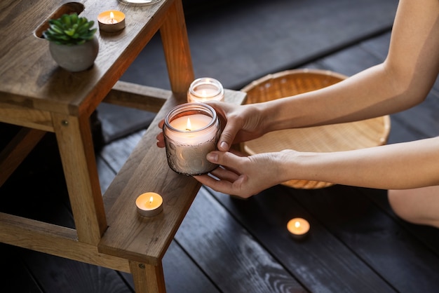 Foto gratuita angolo alto della candela della tenuta della donna