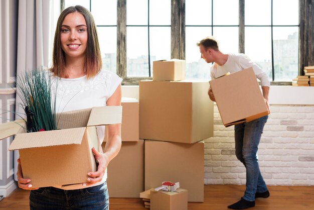 Woman holding a cardboard box with plants