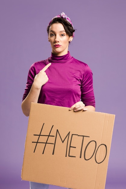 Woman holding a cardboard with "me too" lettering