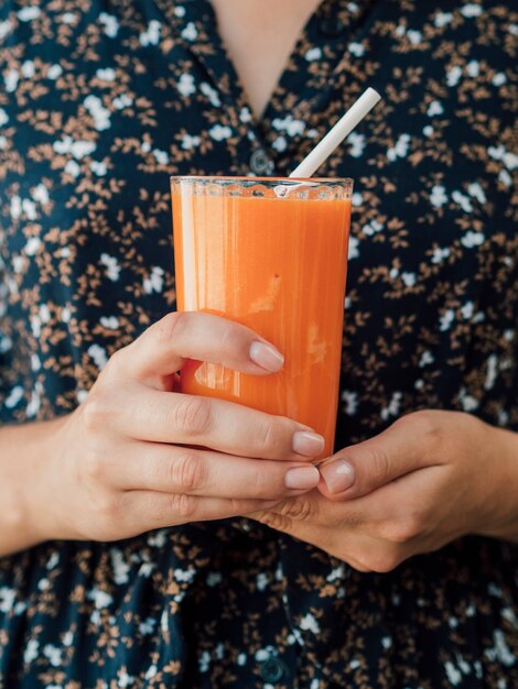 Woman holding carrot juice glass