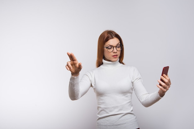 Woman holding cell phone and pushing virtual button