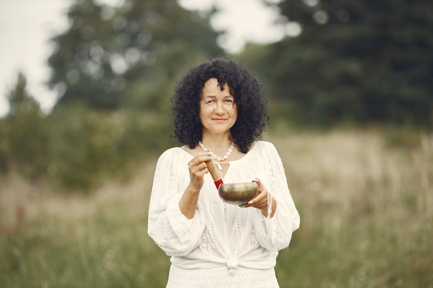 Free photo woman holding chanting bowl in nature setting