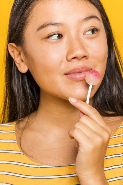 チュッパチャプスを押しながらよそ見の女性