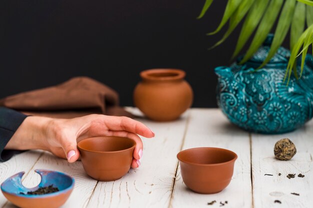 Woman holding clay teacup