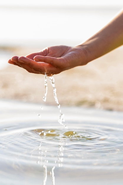 彼女の手で澄んだ水を保持している女性