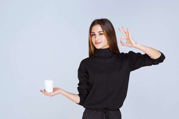 woman holding a coffee cup and enjoying the taste.