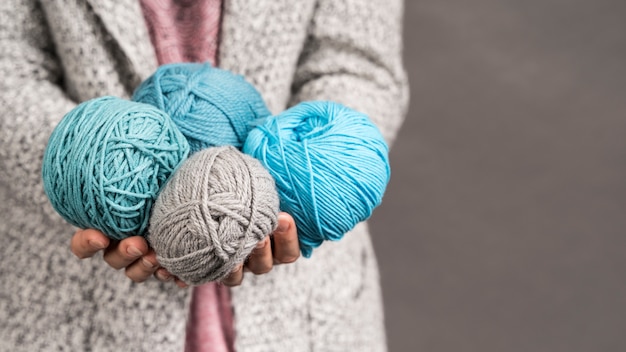 Woman holding colorful wool yarn balls