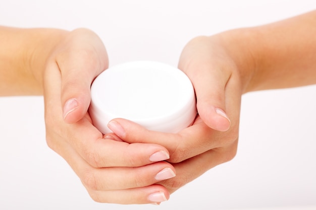 Woman holding a container of cream