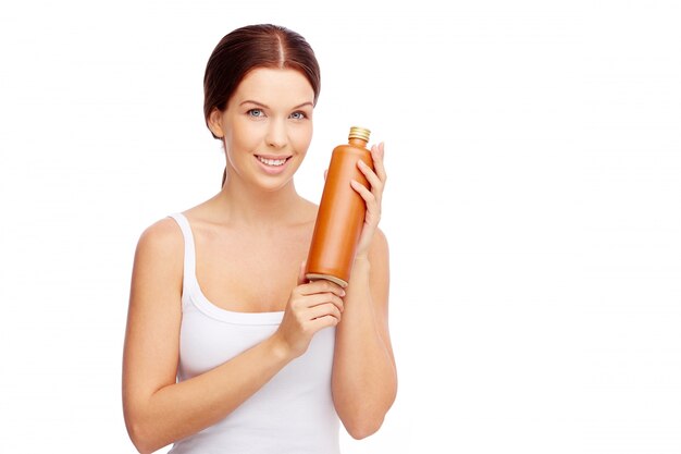 Woman holding a container with sunscreen