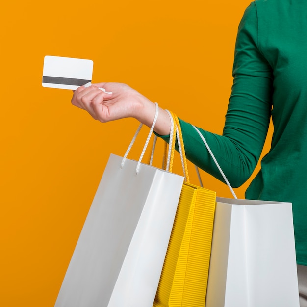 Woman holding credit card and many shopping bags