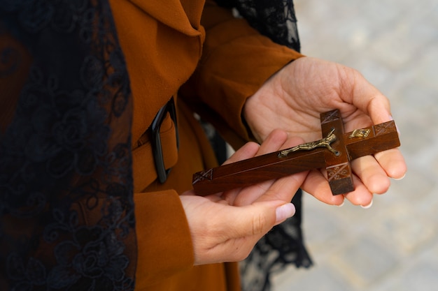 Foto gratuita donna che tiene un crocifisso in chiesa