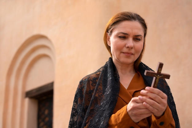 Woman holding a crucifix at church