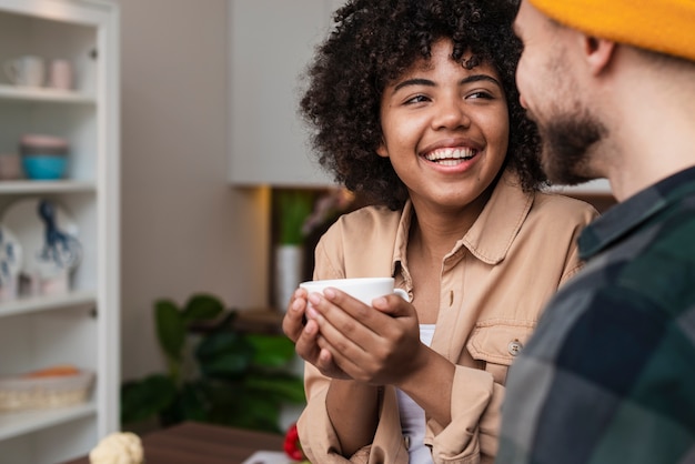 Woman holding a cup of coffee and looking at her boyfriend