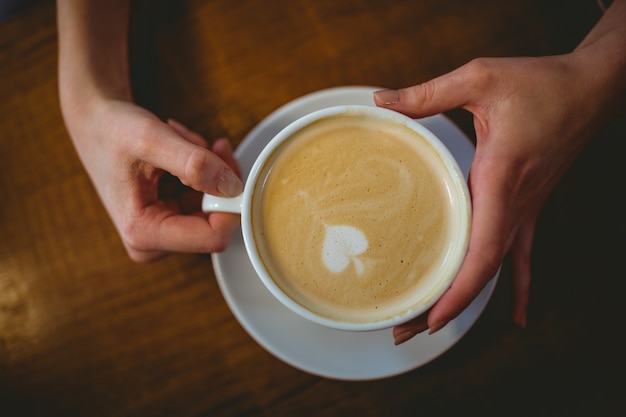 コーヒーカップを保持している女性