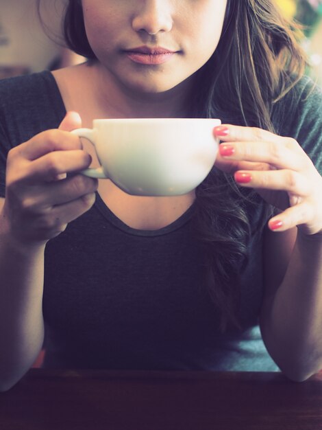 Free photo woman holding a cup of coffee