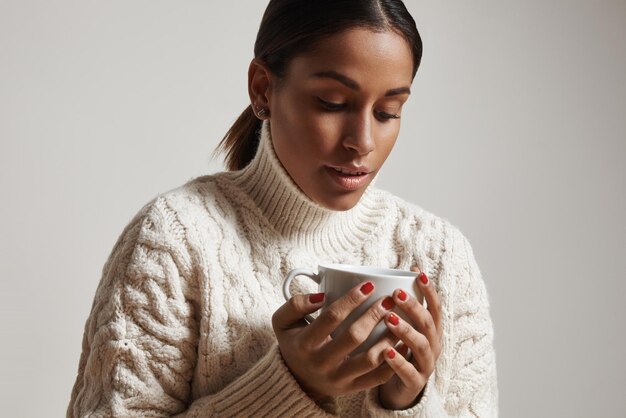 熱いdrinnkのカップを保持している女性