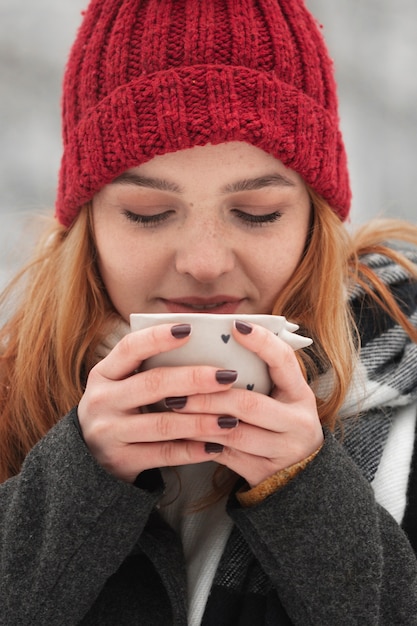 お茶のカップを押しながら一口を飲む女性