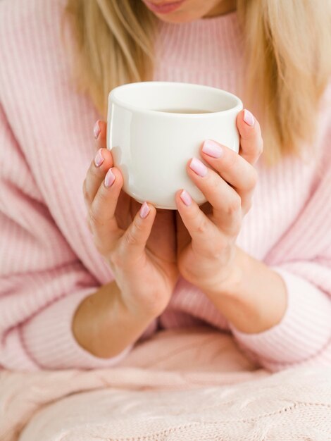 お茶のカップを保持している女性