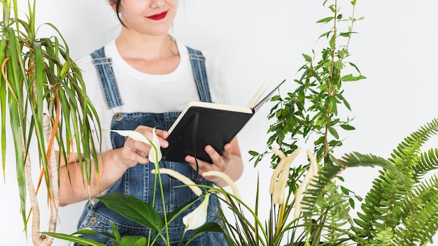 Woman holding diary near plants