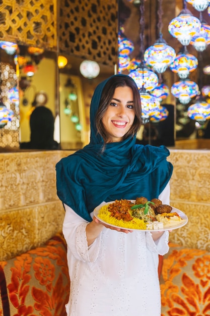 Woman holding dish of arab food