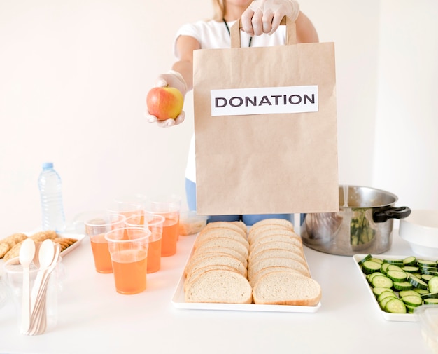 Foto gratuita borsa di donazione della tenuta della donna con alimento