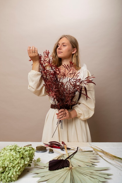 Foto gratuita colpo medio delle piante secche della holding della donna